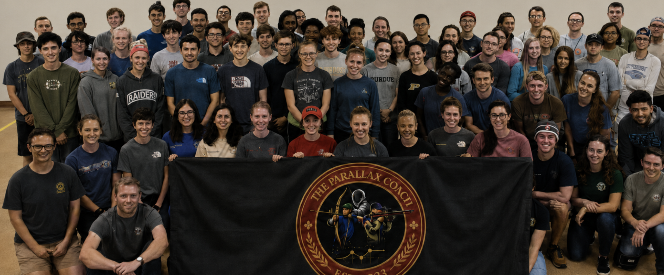 The Parallax Coach community of precision athletes gathered together holding a team banner